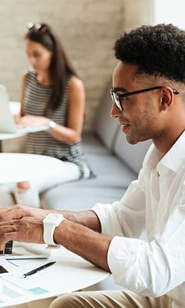 Man checking his smartwatch while sitting in a cafe.