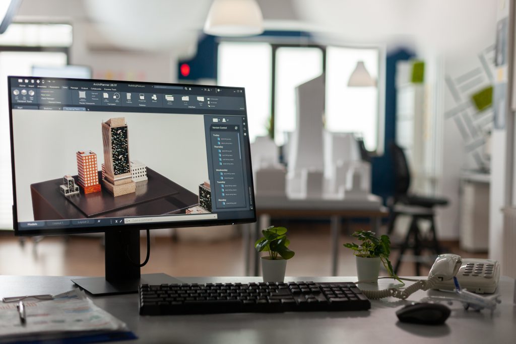 Computer screen showing photo editing of a hand holding a phone in an office.